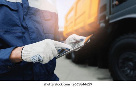Driver man in uniform with tablet computer controls Dump truck. Concept banner automated logistics online internet.