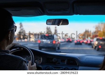 Driver navigating through urban traffic, keeping safe following distance. Red brake lights from vehicles ahead. California. USA.