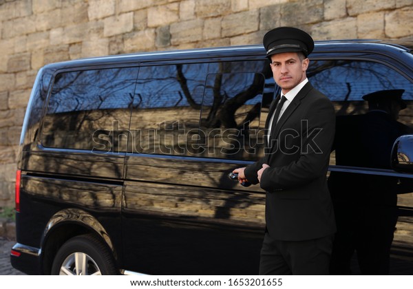 Driver\
opening door of luxury car. Chauffeur\
service