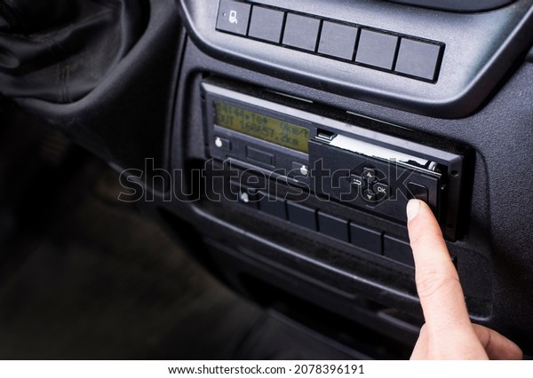 Driver opening\
a printer on a digital tachograph in a van. Paper roll Replacement\
in a truck digital\
tachograph