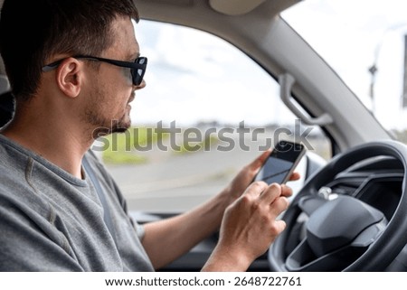 Driver with phone. Man using smartphone in car. GPS navigation checking.