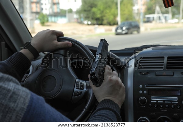 Driver\
with a pistol in a car on the city street.\
Chase.