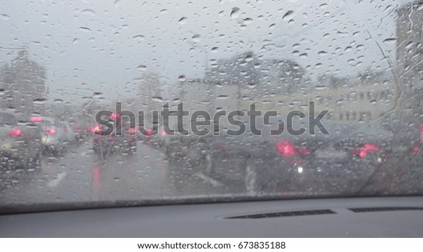 Driver point of view in car\'s windshield on\
the city street. Rain in Moscow,\
may,