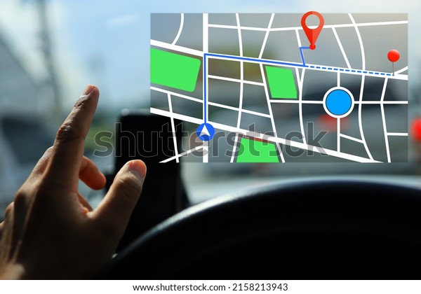 Driver pointing to\
the virtual GPS screen in the car on road to define and select to\
pin destination to go\
to.