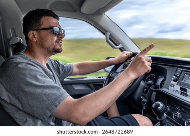 Driver pointing while driving. Man gestures in car. Reaction behind the wheel.