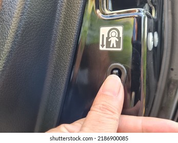 A Driver Is Pressing On Child Lock Button At Car's Door