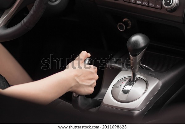 Driver pulling
the hand brake in car. Close
up.