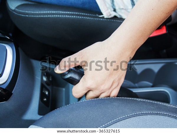 driver pulling the hand\
brake in car 