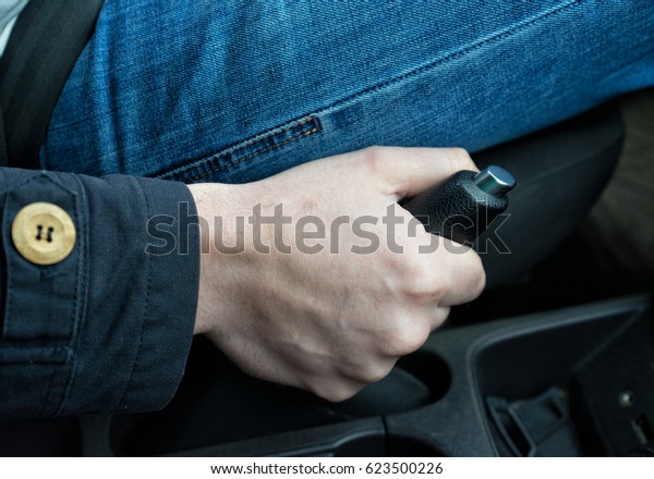 driver pulling the hand\
brake in car