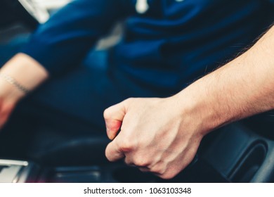 The driver pulls the hand brake lever. Male hand pulling the Parking brake using the hand brake lever. Hand brake for emergency stopping. Stylish Toned Photo - Shutterstock ID 1063103348