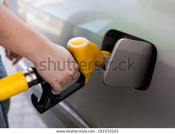 Driver\
pumping gasoline at the gas station,\
closeup