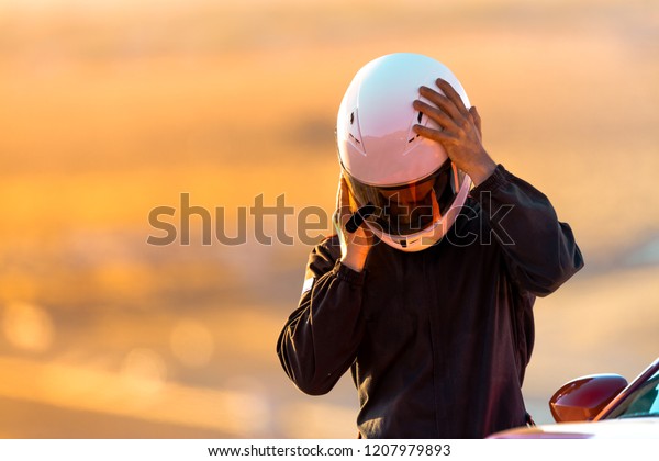 A Driver At Racing School Putting His\
Helmet On Before Taking His Car On To The\
Track.