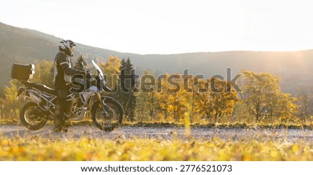 Driver riding motorcycle on empty road during sunset, spring mountains