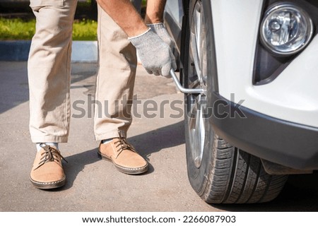 driver screwing the wheel with a wrench. the driver is changing the wheel. car care