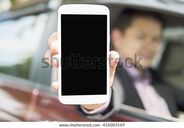 Driver is showing mobile phone with\
black blank screen while sitting in a car. Photo is focused at\
mobile screen and includes CLIPPING PATH for mobile\
screen.