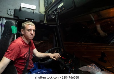 Driver Sits In The Cab Of A Parked Truck  By Night