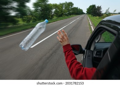 El conductor desechando la botella de plástico de la ventana del auto. Basura en el camino