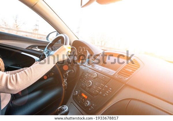 Driver\
training car on road in winter sunny day. Happy young woman inside\
vehicle driving. Vacation ride trip travel\
concept