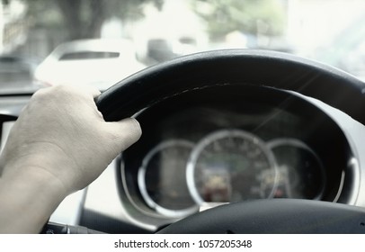 The driver uses only the left hand to force the steering wheel while the car moves slowly.