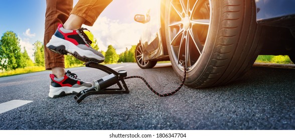 Driver Using A Foot Pump To Inflate A Tire