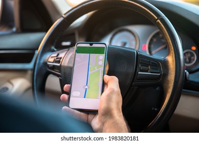 Driver using google maps on mobile phone in the car