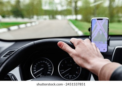 Driver using GPS navigation in mobile phone while driving car.