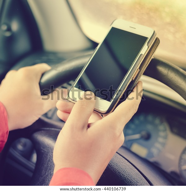 Driver using touch screen smartphone and gps\
navigation in a car. closeup on\
hand