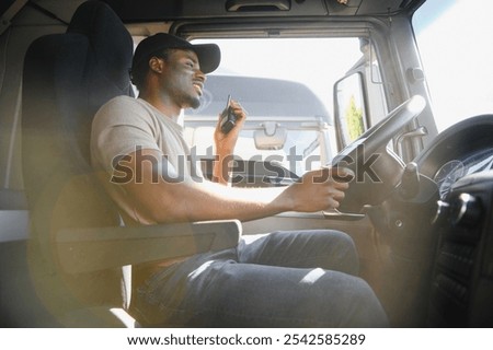 Driver using walkie talkie in cab of modern truck