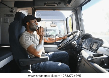 Driver using walkie talkie in cab of modern truck