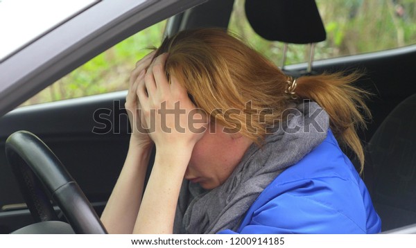 the driver of the woman\
fell asleep on the driver\'s seat on the side of the road. Waiting\
in the car.