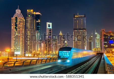 Driverless metro train with skyscrapers in the background - Dubai, the United Arab Emirates.
