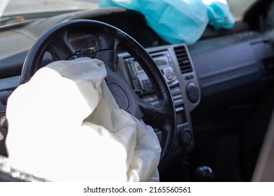 The driver's airbag deployed on the steering wheel of the car after the collision. Deflated airbags after flared deployment. The airbag deployed. Car after an accident. Safety device in the car