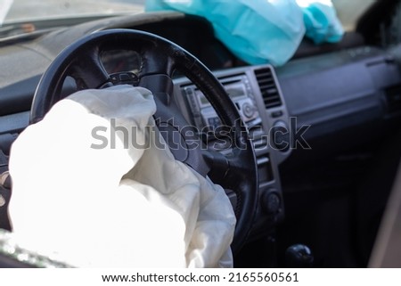 The driver's airbag deployed on the steering wheel of the car after the collision. Deflated airbags after flared deployment. The airbag deployed. Car after an accident. Safety device in the car