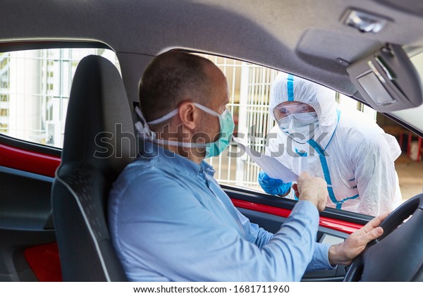 Drivers go to the coronavirus test in the\
drive-in at doctors in protective\
clothing