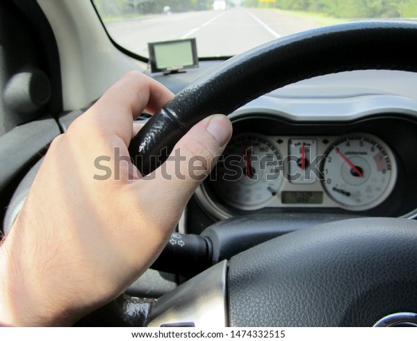 Drivers hand on the steering wheel photo in a car\
interior small