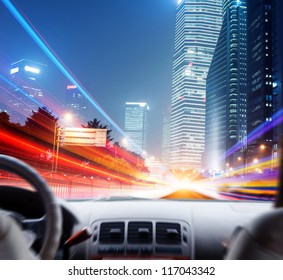 Driver's Hands On A Steering Wheel Of A Car And Night Scene