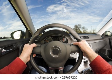 Driver's Hands On Steering Wheel Of Car