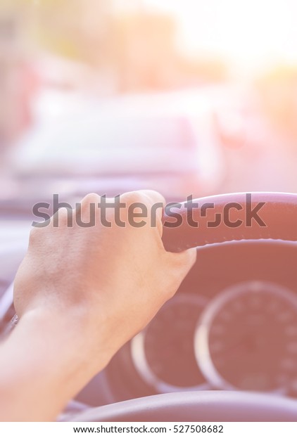 Driver\'s\
hands on the steering wheel inside of a\
car