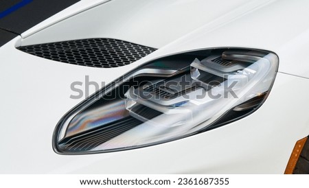 Drivers headlight on a white super car