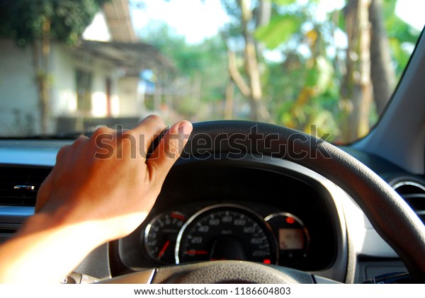the\
driver\'s left hand on the steering wheel of the\
car