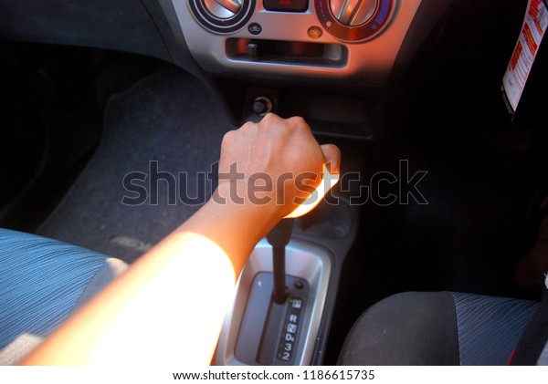 driver\'s left\
hand shifting the gear stick in\
car