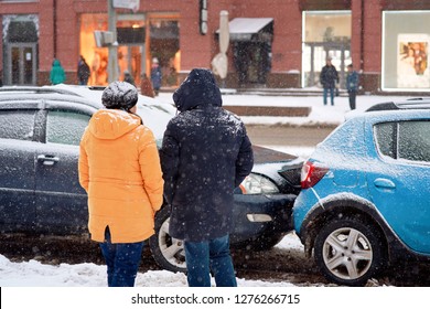 Drivers Look At Damaged Cars After Road Accident In Blizzard. Car Crash Accident On Winter Road With Snow, Safe Distance When Driving On Slippery Roads. Winter Driving - Car Breakdown.