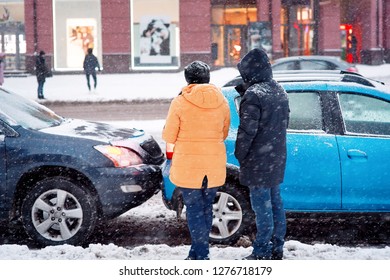 Drivers Look At Damaged Cars After Road Accident In Blizzard. Car Crash Accident On Winter Road With Snow, Safe Distance When Driving On Slippery Roads. Winter Driving - Car Breakdown