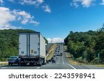 Drivers perspective view over busy and hilly Interstate 84 highway in northerly direction near Willington, CT, USA with trucks and cars on highway