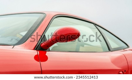 Drivers side mirror on a red car