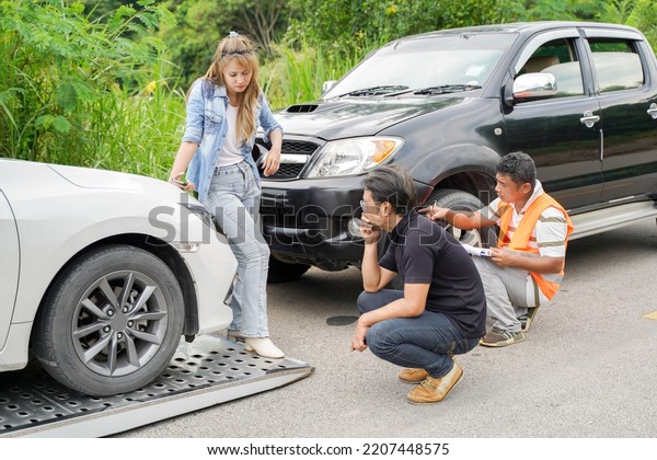 Drivers stood\
arguing after the car crashed with insurance company officer\
checking car damages on country\
road.