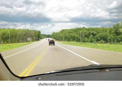 Driver's windshield view of highway. Selective focus on car interior.