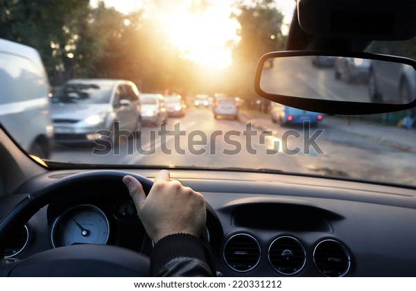 Driving car around\
town in sunny end of a\
day