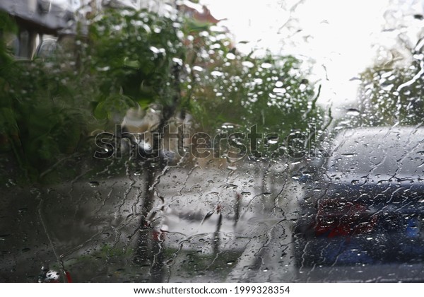 Driving a\
car in bad weather. Driving in a car in heavy rain. Difficult\
visibility from a car through a wet\
windshield
