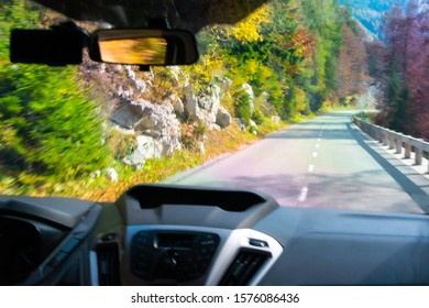 Driving car down the mountains with a caption view of the road taken through the wind shield
